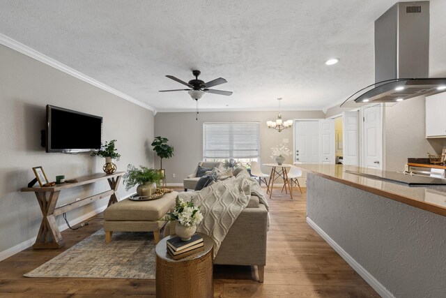 unfurnished living room with ceiling fan, a brick fireplace, hardwood / wood-style floors, a textured ceiling, and ornamental molding