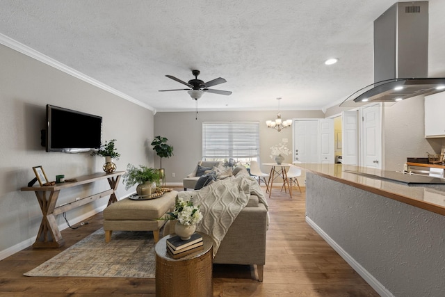 living room with wood-type flooring, ornamental molding, ceiling fan with notable chandelier, and a textured ceiling