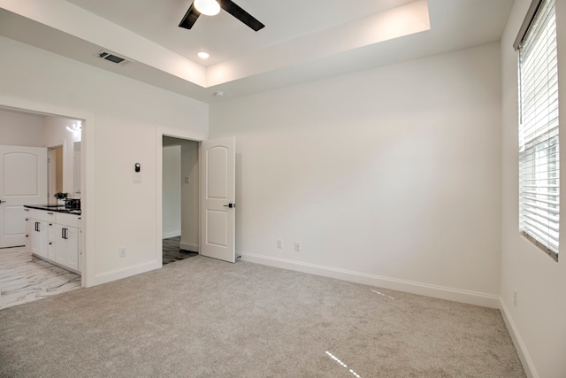 unfurnished bedroom featuring connected bathroom, ceiling fan, and light colored carpet