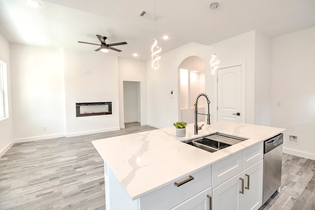 kitchen featuring white cabinetry, dishwasher, sink, decorative light fixtures, and a kitchen island with sink