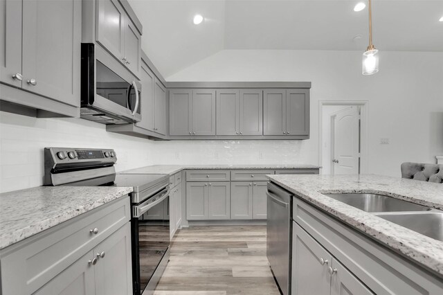 kitchen featuring gray cabinets, hanging light fixtures, light hardwood / wood-style floors, and appliances with stainless steel finishes