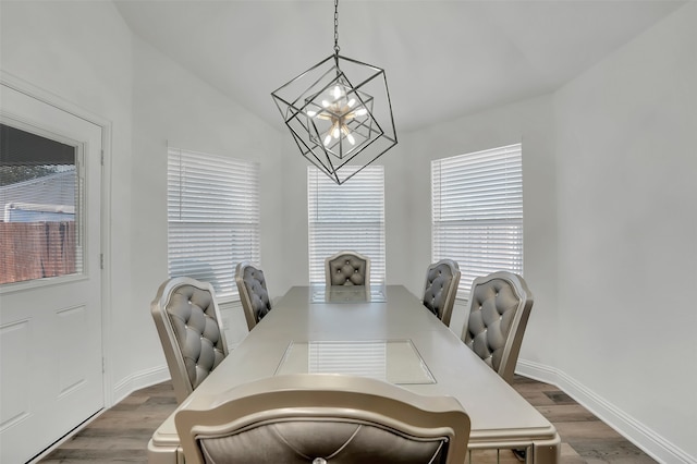 dining space with a chandelier, lofted ceiling, and dark hardwood / wood-style flooring