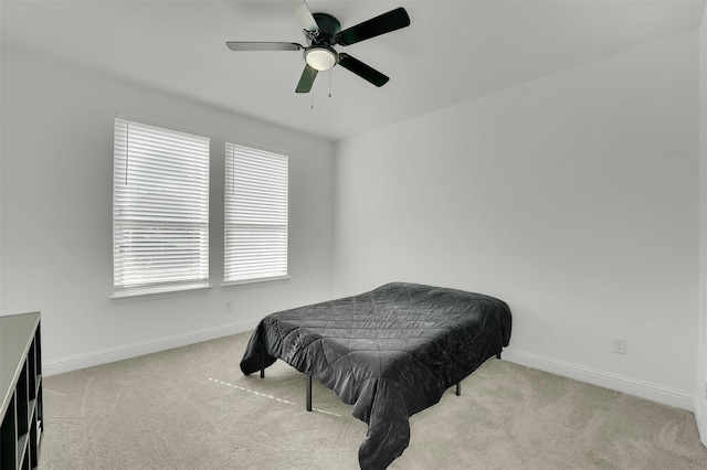 carpeted bedroom featuring multiple windows and ceiling fan