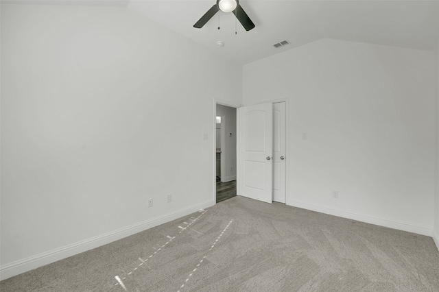 carpeted spare room with ceiling fan and high vaulted ceiling