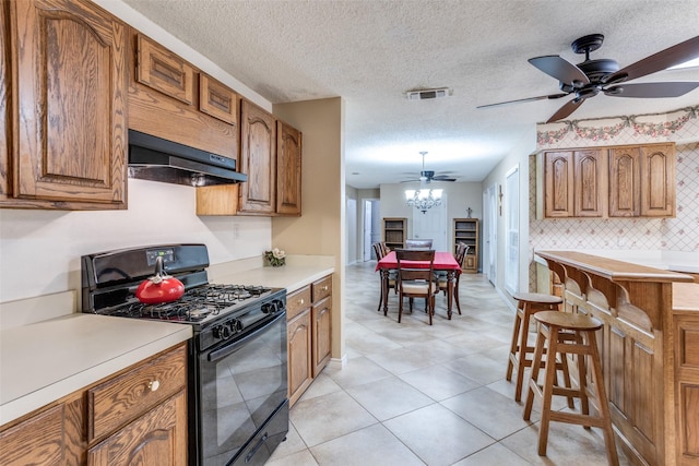 1491 County Road 456, Princeton, TX 75407 - kitchen featuring ceiling fan, black gas range oven, tasteful backsplash, range hood, and light tile patterned flooring