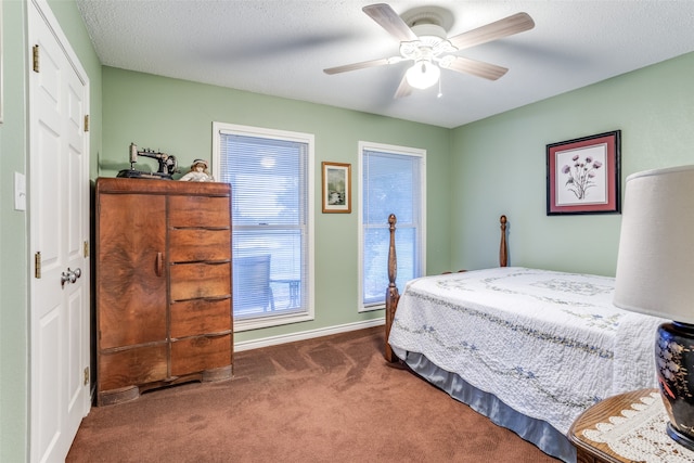 bedroom with ceiling fan, a closet, dark carpet, and a textured ceiling