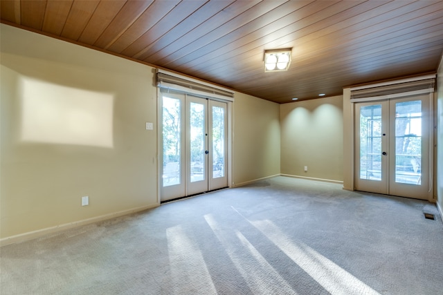 carpeted empty room with plenty of natural light, wood ceiling, and french doors