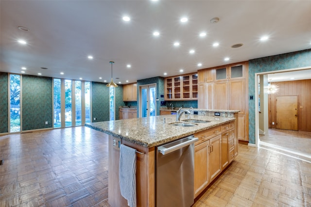 kitchen featuring light parquet flooring, an island with sink, sink, and stainless steel dishwasher