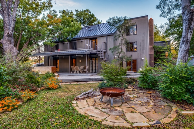 rear view of house featuring an outdoor fire pit, a patio area, and a wooden deck