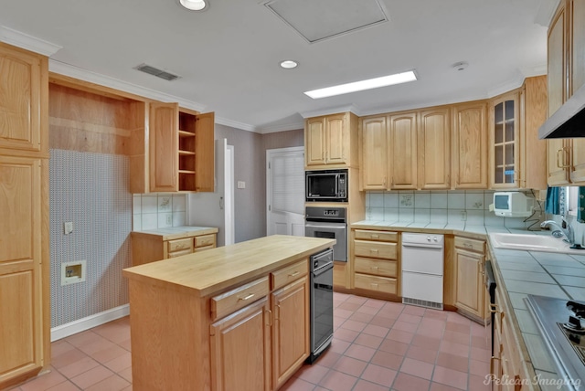 kitchen with a kitchen island, black microwave, sink, tile countertops, and oven