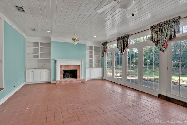 unfurnished sunroom with wood ceiling, a brick fireplace, ceiling fan, and a healthy amount of sunlight