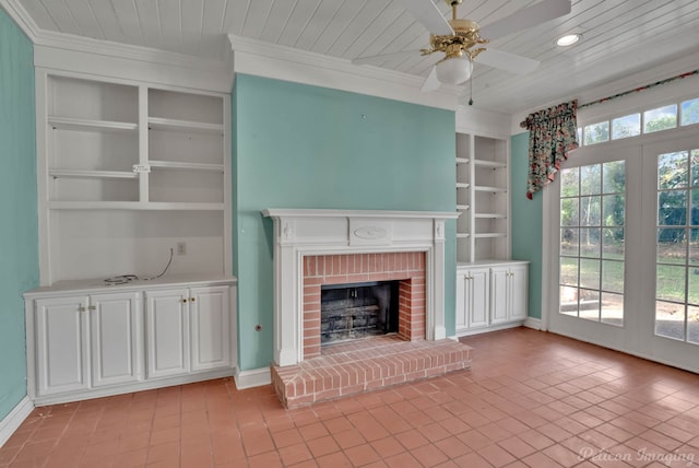 unfurnished living room featuring a fireplace, light tile patterned floors, built in shelves, crown molding, and ceiling fan