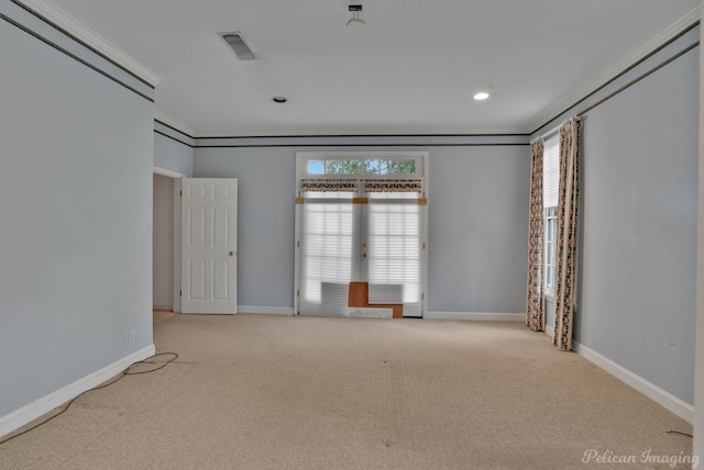 carpeted empty room featuring a healthy amount of sunlight and ornamental molding