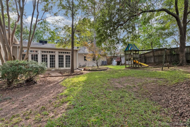 view of yard featuring french doors, a playground, and cooling unit