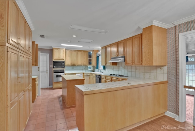 kitchen featuring tile counters, a center island, kitchen peninsula, black appliances, and ornamental molding