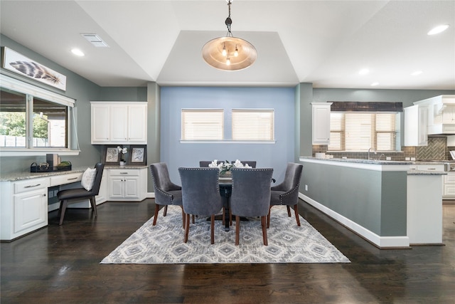 dining space featuring built in desk, plenty of natural light, and dark hardwood / wood-style flooring