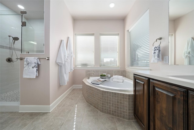 bathroom with vanity, tile patterned floors, and a relaxing tiled tub