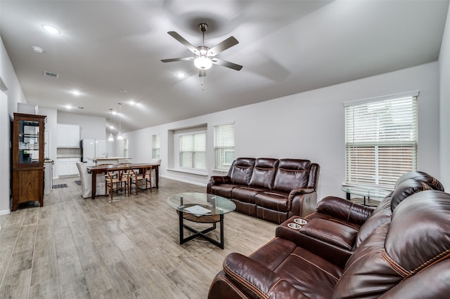 living room with vaulted ceiling, light hardwood / wood-style flooring, a wealth of natural light, and ceiling fan