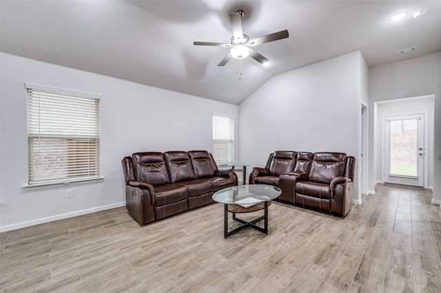 living room featuring vaulted ceiling, light hardwood / wood-style flooring, ceiling fan, and a healthy amount of sunlight