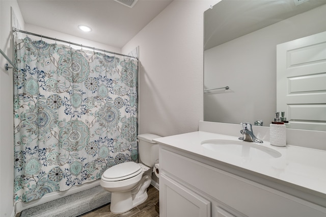 bathroom featuring hardwood / wood-style floors, vanity, toilet, and curtained shower