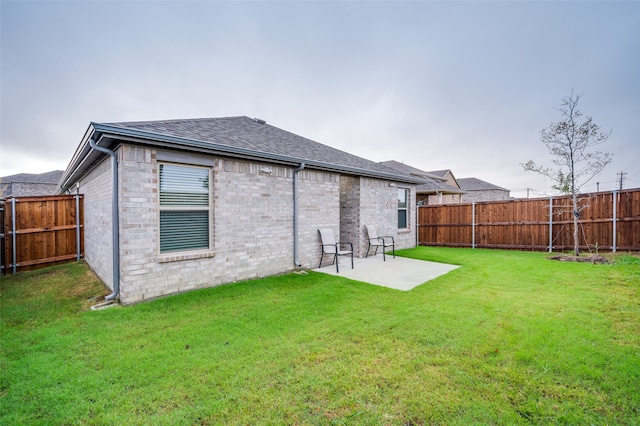 back of house with a yard and a patio