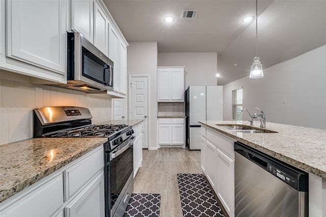 kitchen with white cabinetry, sink, hanging light fixtures, light hardwood / wood-style flooring, and appliances with stainless steel finishes