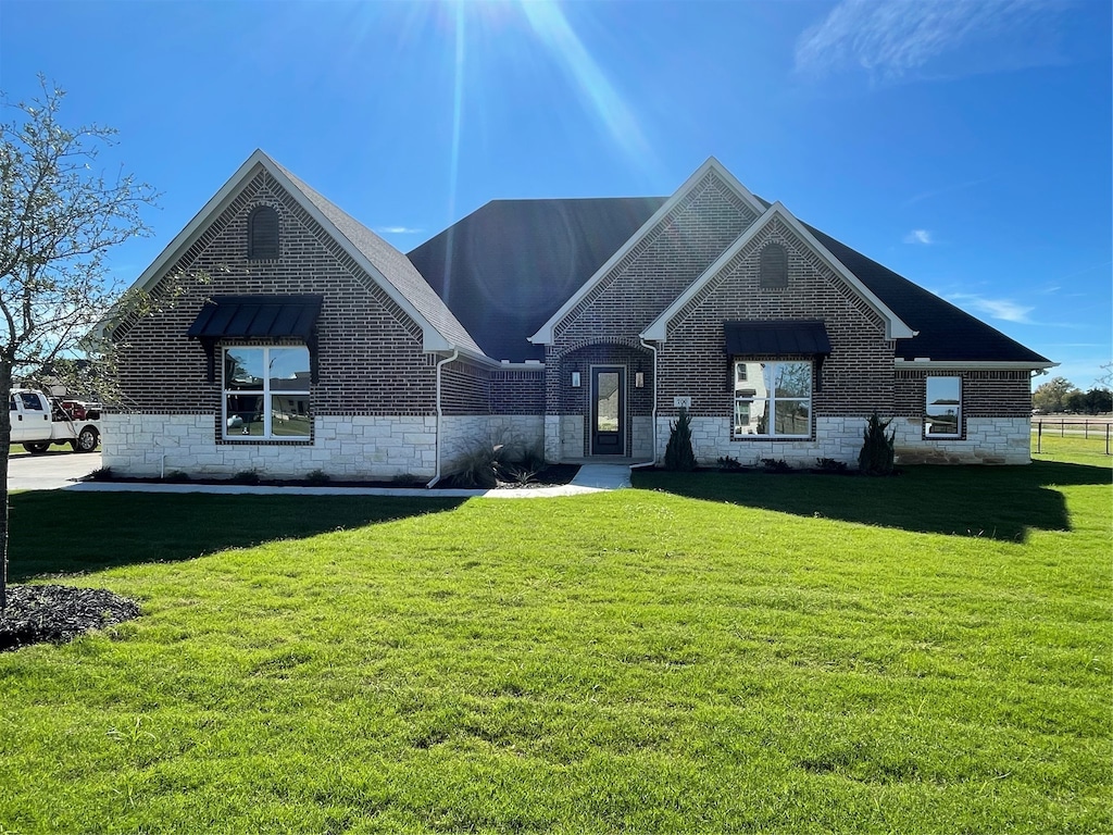 french country style house with a front yard