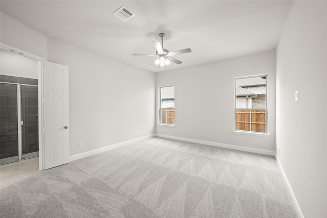 carpeted empty room with visible vents, ceiling fan, and baseboards