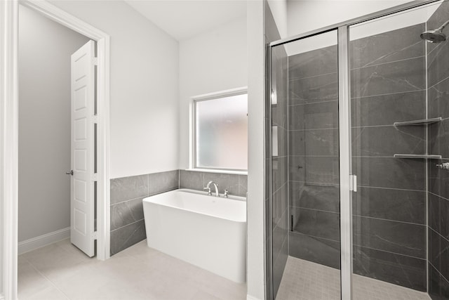 bathroom featuring tile patterned flooring, a shower stall, tile walls, and a freestanding tub