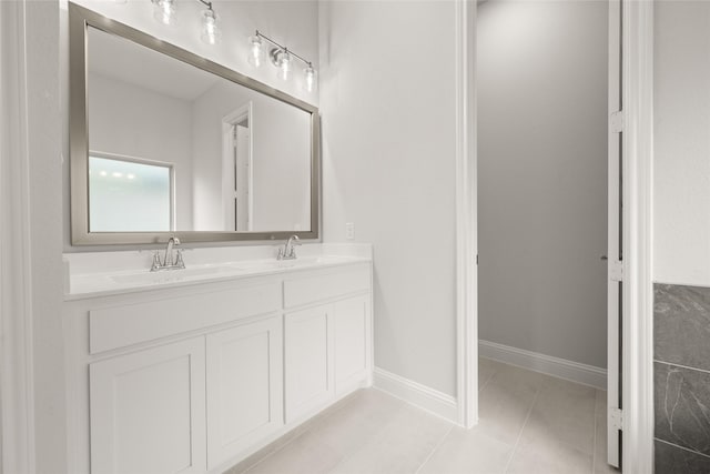 full bathroom with tile patterned flooring, double vanity, baseboards, and a sink