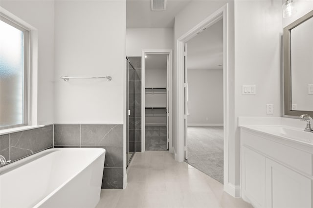 full bathroom featuring a wealth of natural light, visible vents, vanity, and a soaking tub