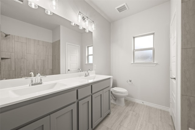 full bathroom featuring toilet, visible vents, a wealth of natural light, and a sink