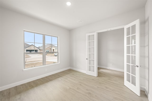 spare room with recessed lighting, french doors, baseboards, and light wood finished floors