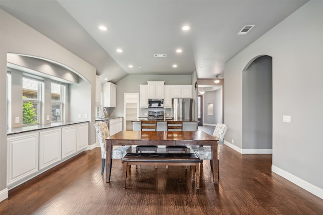 dining space featuring lofted ceiling, sink, and dark hardwood / wood-style floors