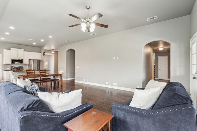 living room featuring dark hardwood / wood-style flooring and ceiling fan