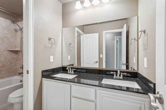 full bathroom with vanity, toilet, and tiled shower / bath combo