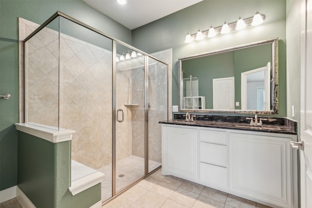 bathroom with tile patterned flooring, vanity, and walk in shower