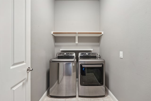 laundry room featuring washing machine and dryer and light tile patterned floors