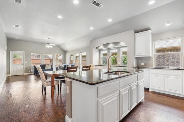 kitchen with white cabinetry, sink, vaulted ceiling, a kitchen island with sink, and stainless steel dishwasher