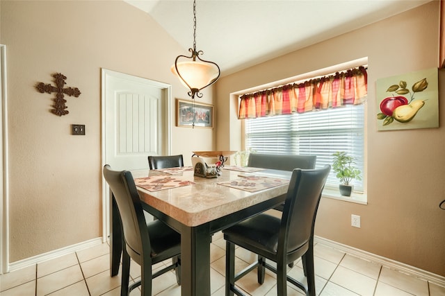 dining space featuring a healthy amount of sunlight, light tile patterned flooring, and vaulted ceiling