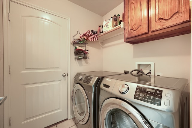 laundry area with cabinets, light tile patterned floors, and washer and dryer