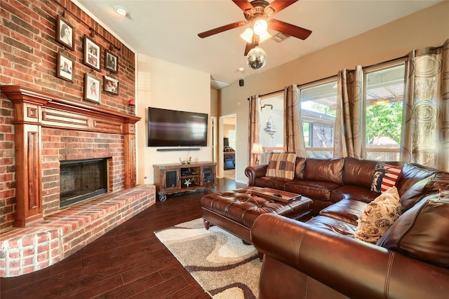 living room with ceiling fan, dark hardwood / wood-style flooring, and a brick fireplace