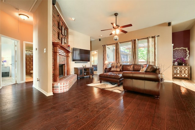 living room with ceiling fan, dark hardwood / wood-style floors, and a brick fireplace