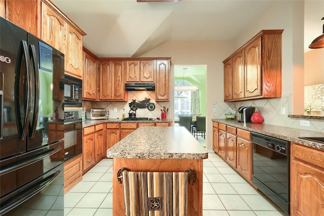 kitchen with black appliances, decorative backsplash, a center island, and light tile patterned flooring