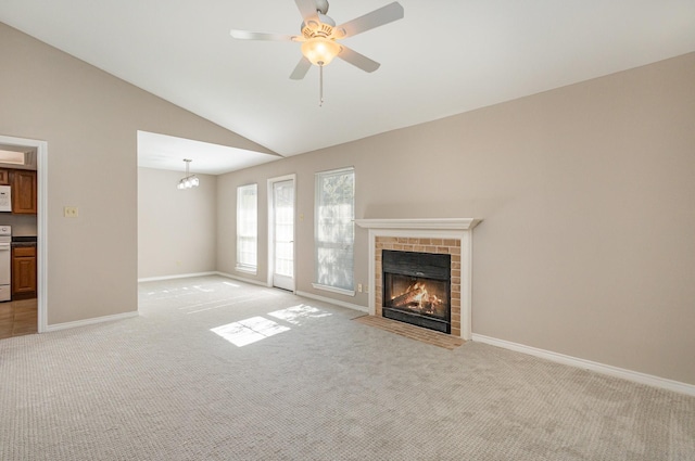 unfurnished living room featuring baseboards, light colored carpet, a fireplace, and vaulted ceiling