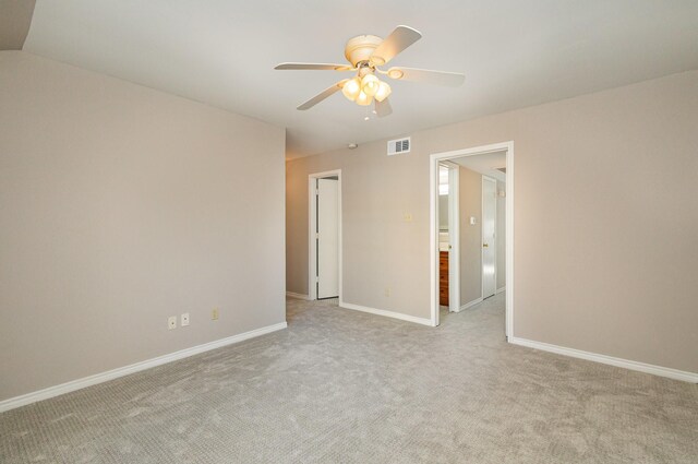 empty room featuring vaulted ceiling, ceiling fan, and light carpet