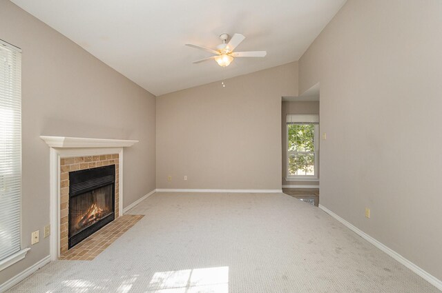 unfurnished living room with a tile fireplace, light carpet, ceiling fan, and lofted ceiling