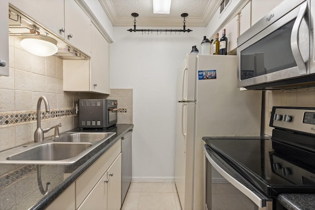 kitchen featuring appliances with stainless steel finishes, backsplash, a textured ceiling, sink, and white cabinets