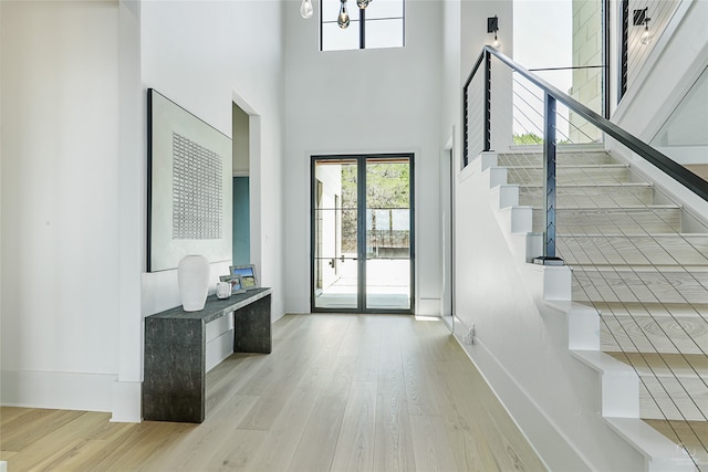 foyer featuring a chandelier, a high ceiling, and light hardwood / wood-style floors