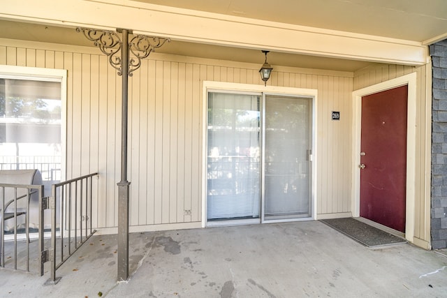 view of exterior entry with a patio